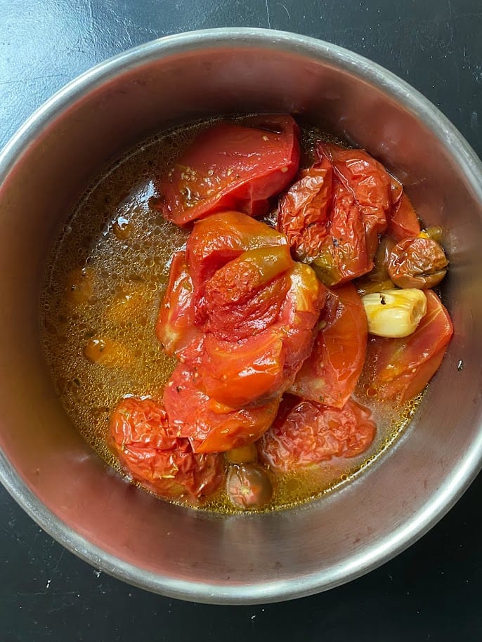 Oven roasted tomatoes from the oven transfered to a large pot